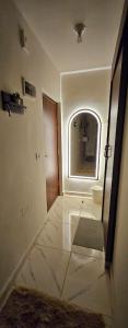 ein Flur mit einem Badezimmer mit Spiegel und Tür in der Unterkunft Studio Carmen with a Pool View in El-Alamein + 13 Fotos
