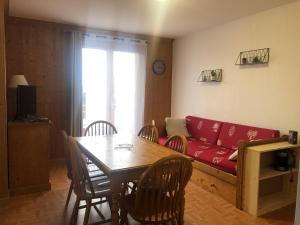a living room with a red couch and a table at Appartement La Toussuire in La Toussuire
