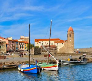two boats are docked in the water near a building at Loft vue Canigou - Maureillas in Maureillas