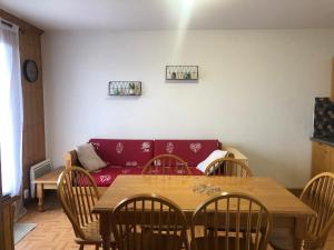 a living room with a red couch and a table at Appartement La Toussuire in La Toussuire