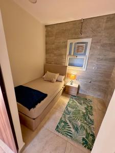 une petite chambre avec un lit et un tapis dans l'établissement Alamein 2 bedroom الحي اللاتيني, à El Alamein