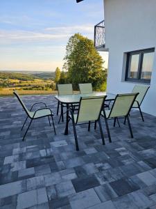a table and chairs on a patio with a view at Vacation home Vilim in Kamešnica +8 photos