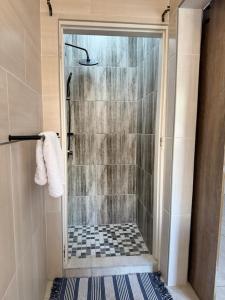 a shower with a glass door in a bathroom at House6705 Air B&B in Maun Airport