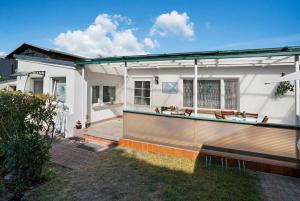 a white house with a porch and a patio at Ferienbungalows Werner in Ostseebad Koserow