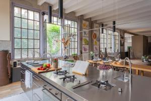 a kitchen with a stainless steel counter top and windows at Design Loft with Private Parking by Rent All Como in Como