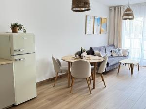 a kitchen and living room with a table and a couch at Apartament Sunset Resort Grzybowo in Grzybowo