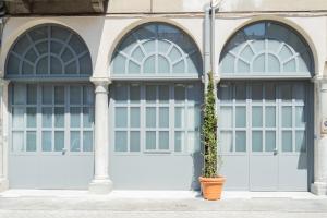a building with two garage doors with a plant in a pot at Romantic Escape city centre with Jacuzzi & Parking by Rent All Como in Como