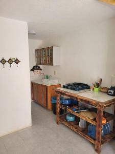 une cuisine avec une table en bois et un comptoir dans l'établissement Casa Amarilla, à Barrio Nuevo