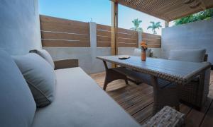 a patio with a table and chairs and a wooden deck at T2 cosy proche nature et centre- La Verrière in La Possession