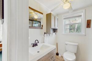 a white bathroom with a sink and a toilet at Moonlighting in Edisto Beach +21 photos