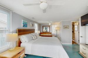 a bedroom with a white bed and a ceiling fan at Moonlighting in Edisto Beach