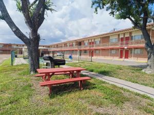 een rode picknicktafel voor een gebouw bij Pen Ann by Capital O Pharr-McAllen TX in Pharr