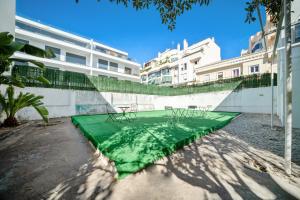un campo verde con delle sedie di fronte a un edificio di Plaza Inn Hostel & Rooms a Faro