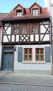 アッシャースレーベンにあるFerienhaus am Markt - ANNO 1708 - App 1の青いドアと窓のある通りの建物