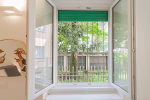 a window in a room with a view of a tree at A Step from the Lake Apartment by Rent All Como in Como