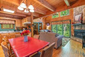 eine Küche und ein Wohnzimmer mit einem roten Tisch in einer Hütte in der Unterkunft Heartwood in Sevierville