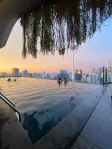 a pool on the roof of a building with a city in the background at Ceylonz Suites by Stayla in Kuala Lumpur