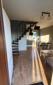 a living room with a staircase and a dining room at Biały Źagiel in Jantar