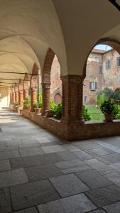 an arcade with arches and potted plants in a building at CASA MIRELLA in Casale Monferrato