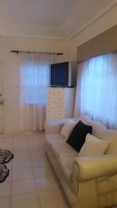 een woonkamer met een witte bank en een televisie bij Kingston Studio Apartment in Kingston