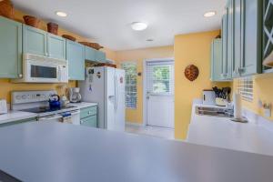 una cucina con armadi blu e frigorifero bianco di Cayman Cottage On Cemetery Beach a West Bay