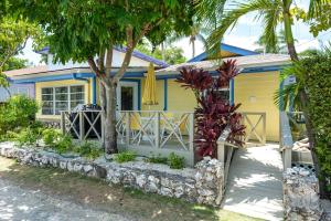 una casa gialla con palme di fronte di Cayman Cottage On Cemetery Beach a West Bay Altre 16 foto