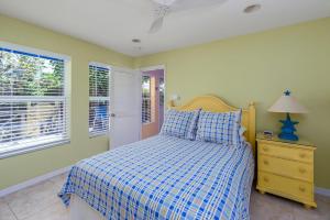 una camera con un letto con una coperta a scacchi blu e bianca di Cayman Cottage On Cemetery Beach a West Bay