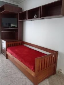 ein Holzbett mit roter Matratze und Schränken in der Unterkunft 1 Ambiente Zona Shopping Aldrey in Mar del Plata