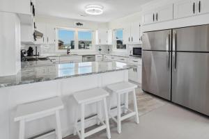a kitchen with white cabinets and a stainless steel refrigerator at 8720 - Beach Please (Frisco) in Frisco