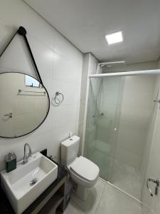 a bathroom with a shower and a toilet and a sink at Studio Charmoso Próximo ao Parque do Lago - SPMA01 in Guarapuava +19 photos