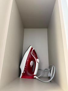 a red and white telephone sitting in a box at Studio Charmoso Próximo ao Parque do Lago - SPMA01 in Guarapuava