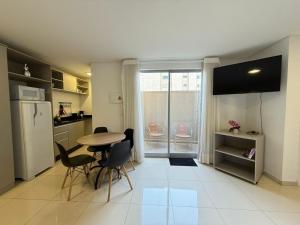 a kitchen with a table and chairs and a refrigerator at Studio Charmoso Próximo ao Parque do Lago - SPMA01 in Guarapuava
