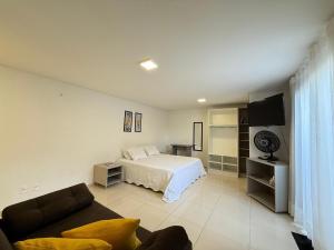 a living room with a bed and a couch at Studio Charmoso Próximo ao Parque do Lago - SPMA01 in Guarapuava