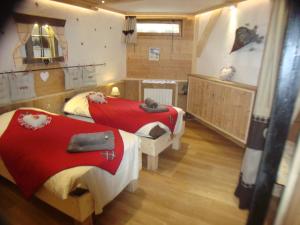 a bedroom with two beds with red sheets at Chalet l'Avalin in Val dʼIsère