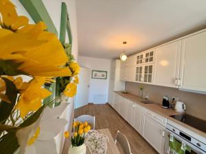 a kitchen with a table and a yellow flower in a vase at Vesel Fluturas Chic Apartment in Timişoara