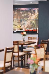 Santa Inn Hotel في باليريو كامبوريو: غرفة طعام مع طاولة وكراسي وصورة كبيرة +99 صورة