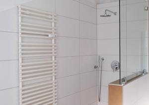 ein Bad mit einer Dusche und weißen Fliesen in der Unterkunft CASA LUXE - 110qm - Stadtmitte - Familienfreundlich - Parkplatz - 5km zum Legoland in Günzburg