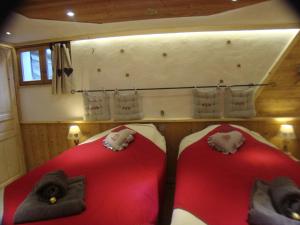 two beds in a room with red and white sheets at Chalet l'Avalin in Val dʼIsère