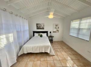 a bedroom with a bed in a white room at Beautiful 4 Br3 Ba South Sound Home Wpool in George Town +17 photos