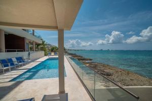 a swimming pool next to the ocean next to a building at Sea Dreams 3-contemporary Condo Wpanoramic Views in West Bay