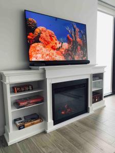 a living room with a fireplace with a flat screen tv at Sea Dreams 3-contemporary Condo Wpanoramic Views in West Bay