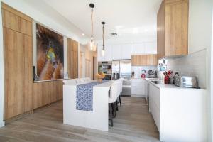 a kitchen with white counter tops and wooden cabinets at Sea Dreams 3-contemporary Condo Wpanoramic Views in West Bay