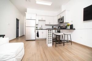 a kitchen with white cabinets and a table and chairs at Seamist 308 Views Of North Sound in West Bay