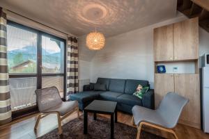 salon z niebieską kanapą i 2 krzesłami w obiekcie Apartment Jamy w Tatrzańskiej Łomnicy
