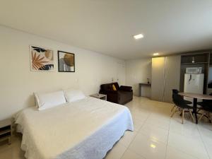 a bedroom with a bed and a table and a couch at Studio Charmoso para até 6 pessoas - SPMB02 in Guarapuava
