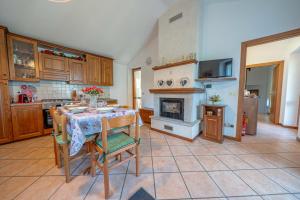 a kitchen with a table with chairs and a fireplace at La Rosa Bianca in Morbegno