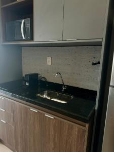Una encimera de cocina con fregadero y microondas. en Stay In- Consolação - conforto e acolhimento com uma vista incrível em uma excelente localização Portaria 24h, en São Paulo