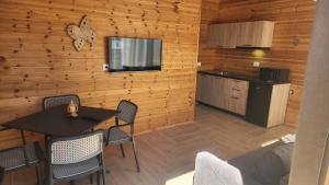 a room with a table and chairs and a kitchen at UniKlajd Villa-s in Golem