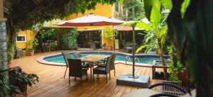 a patio with a table and chairs and an umbrella at Apart Hotel La Cordillera in San Pedro Sula