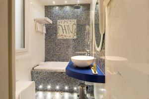 La salle de bains est pourvue d'un lavabo et d'une baignoire. dans l'établissement Hotel Residence Henri IV, à Paris